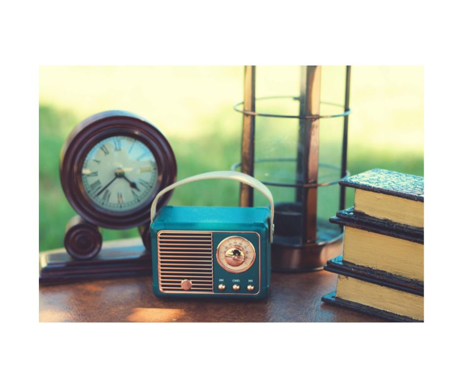 デスクの上のアナログ時計とラジオと本