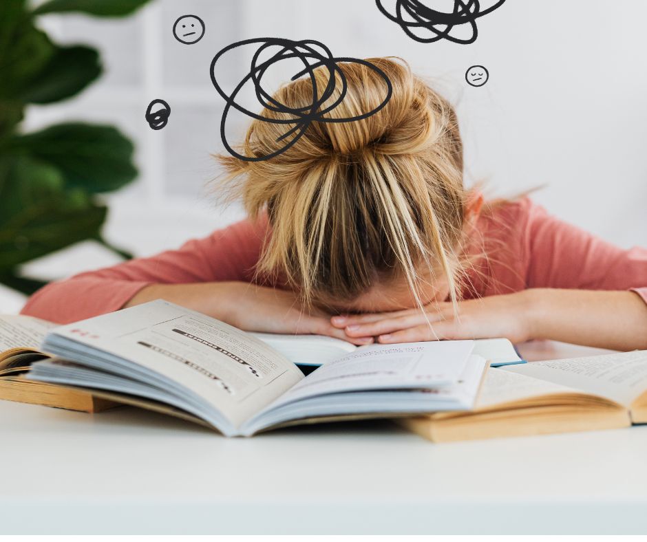 たくさんの書類に顔を伏せて疲れている人